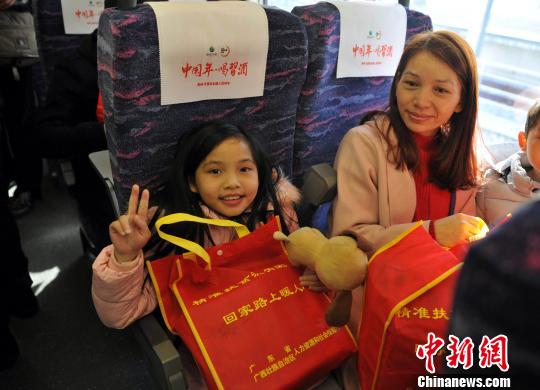 图为小旅客收到爱心礼包开心不已。　黄千航 摄